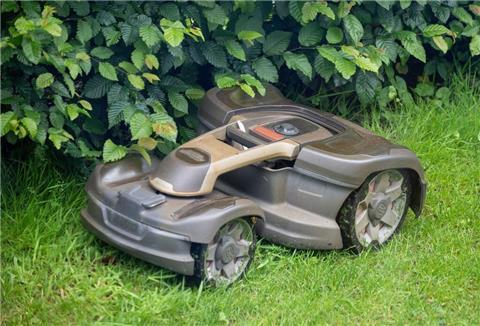 Ein Mähroboter mäht Gras in einem Garten. 