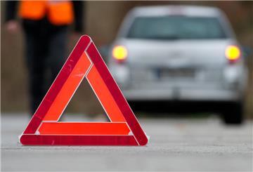 Ein Warndreieck steht auf einer Straße. Im Hintergrund ist ein Auto zu sehen. Ab 2026 darf das Warndreieck in Spanien nicht mehr genutzt werden, denn es gibt eine Alternative.