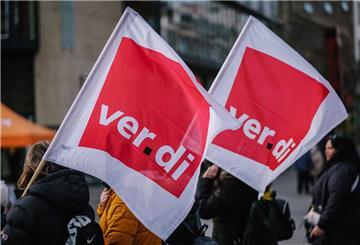 Beschäftigte der Sozial- und Erziehungsberufe demonstrieren mit Verdi-Fahnen.