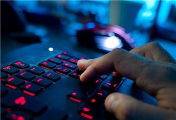 Ein Mann sitzt am Rechner und tippt auf einer Tastatur.