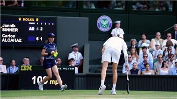 Was liegt denn da? Jannik Sinner hebt einen Champagnerkorken auf.