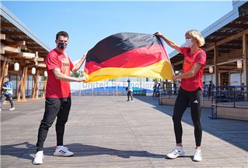 Wasserspringer Patrick Hausding und Beachvolleyballspielerin Laura Ludwig halten schon mal eine Deutschlandfahne.