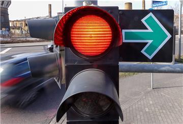 Eine rote Ampel mit einem grünen Pfeil.