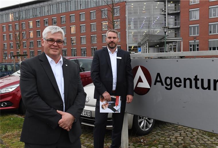 Neuer Chef in Bremerhavens Arbeitsagentur Wolfgang Mögenburg und Frank Westphal stehen neben dem Schild mit der Aufschrift Agentur für Arbeit