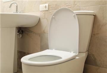 Das Bild zeigt eine Toilette und ein Waschbecken. Wegen hoher Mieten ist eine junge Chinesin in die Toilette ihres Büros eingezogen.
