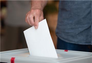 Ein Wähler wirft in einem Wahllokal seinen Stimmzettel in die Wahlurne: 