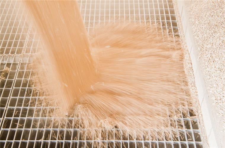 Weizen rieselt durch ein Rost in einen Schacht. Auf dem Gelände der Raiffeisen-Warengenossenschaft in Wilstedt gehört die Verladung von Getreide zum Alltag. Für die Anlieger problematisch ist die Anlage, in der Getreide, in erster Linie Mais, getrocknet wird.