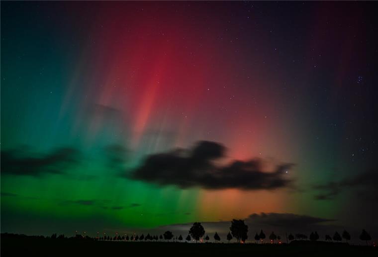 Polarlichter leuchten am Nachthimmel über der Landschaft im östlichen Brandenburg