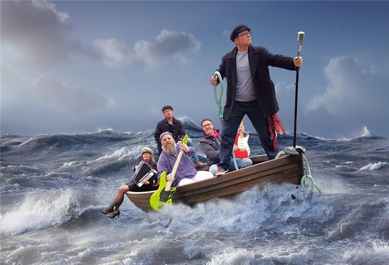 Fünf Musiker sitzen scheinbar bei hohem Wellengang in einem Holzboot.