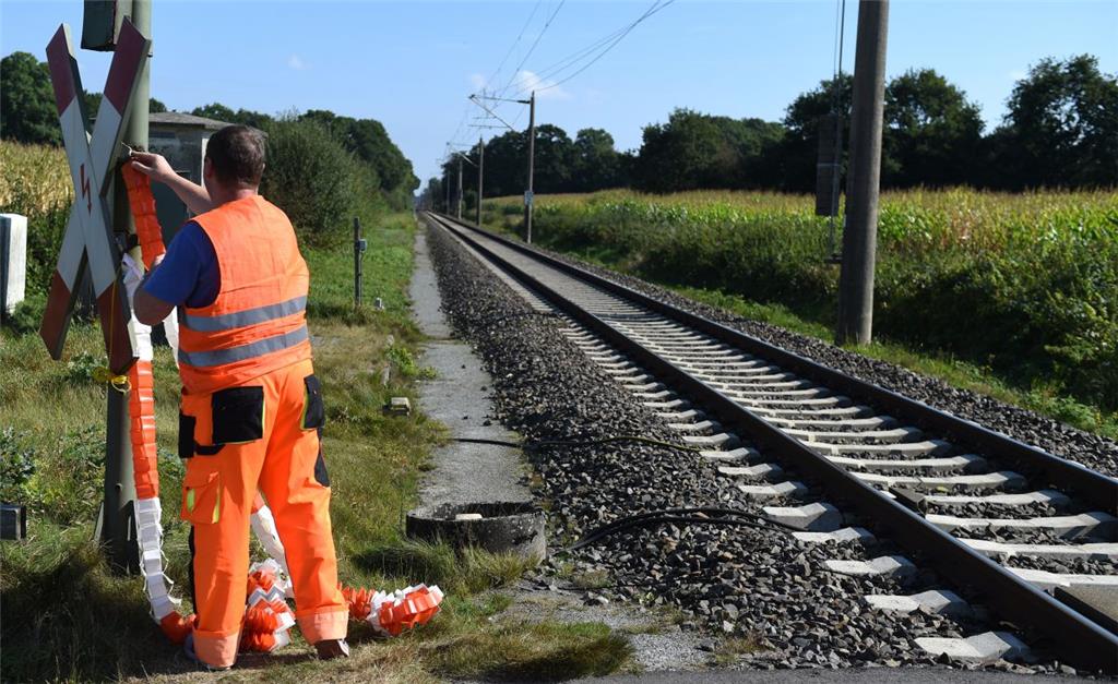 Wenn ein Zug kommt, muss der Bahnübergab mit einer rot-weißen Girlande gesichert...