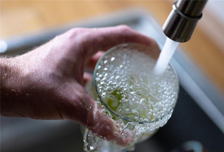 So merkst du, ob du genug getrunken hast – diese Tipps helfen Tinkwasser läuft aus dem Wasserhahn in einer Küche in ein Glas mit Limettenstücken