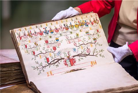 Margit Ksoll-Marcon, Generaldirektorin der Staatlichen Archive Bayerns, hält im Archivraum des Staatsarchivs ein Buch mit einem alten Stammbaum. 