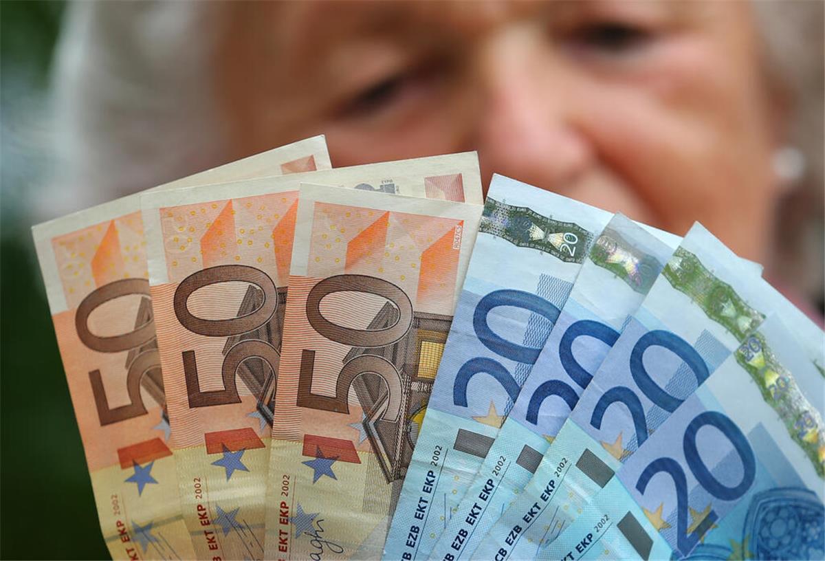 Renten-Abzocke durch Steuerklasse 5? Das solltest du wissen! Eine Rentnerin hält verschiedene Euroscheine in ihren Händen