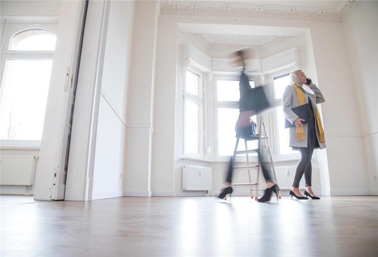 Zwei Frauen stehen in einem leeren Haus. 