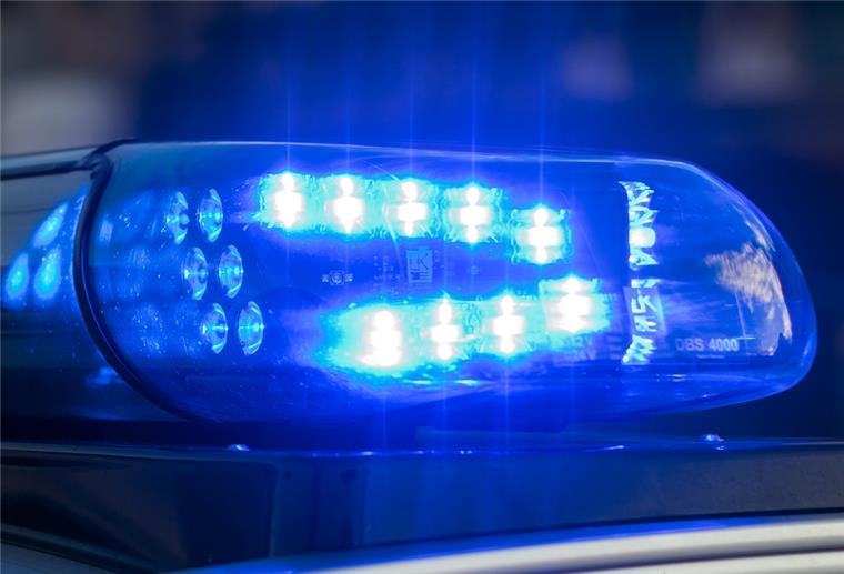 Das Blaulicht auf einem Fahrzeug der Polizei leuchtet in der Dunkelheit.
