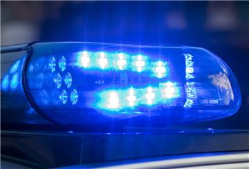 Das Blaulicht auf einem Fahrzeug der Polizei leuchtet in der Dunkelheit.