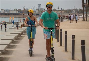 Menschen fahren mit einem E-Scooter am Strand entlang