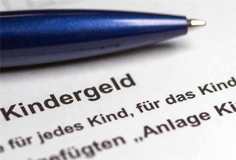 Kindergeld-Falle vermeiden: So gibt es mehrere Monate obendrauf Ein Stift liegt auf einem Kindergeldbescheid.