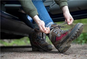 Autofahrer zieht Wanderschuhe an