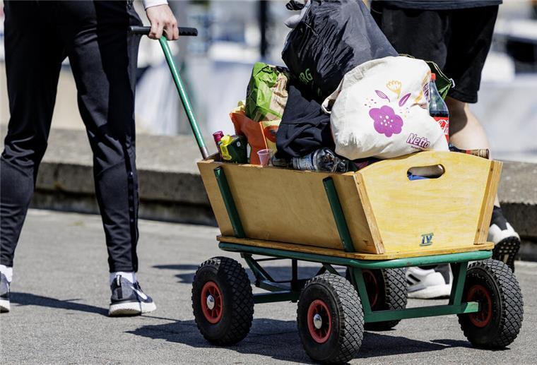 Eine Gruppe junger Menschen ist mit einem Bollerwagen unterwegs