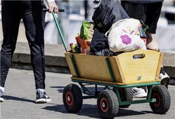 Eine Gruppe junger Menschen ist mit einem Bollerwagen unterwegs