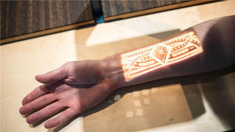 „Der blaue Kontinent“: Neue Pazifik-Ausstellung in Bremen Wer möchte, kann sich pazifische Tätowierungen auf den Arm projizieren lassen.