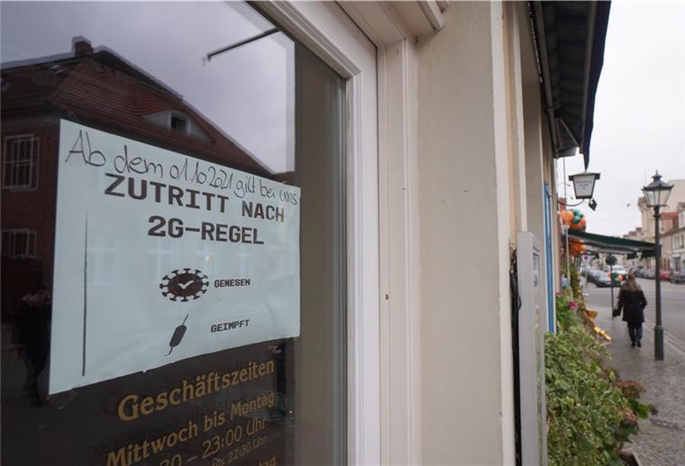 Ein Schild, das auf die 2G-Regel hinweist, ist an der Eingangstür eines Restaurants zu sehen. Die schärferen Corona-Regeln treten in Brandenburg in Kraft. Die 2G-Regel mit Zutritt nur für Geimpfte und Genesene wird für einige Bereiche zur Pflicht, dazu kommt eine Maskenpflicht in Grundschulen. 