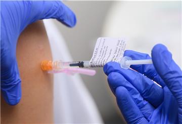 Eine Ärztin impft im Universitätsklinikum Carl Gustav Carus Dresden einen Arztkollegen mit der dritten Impfung mit dem Wirkstoff Comirnaty von Biontech/Pfizer gegen das Coronavirus. 