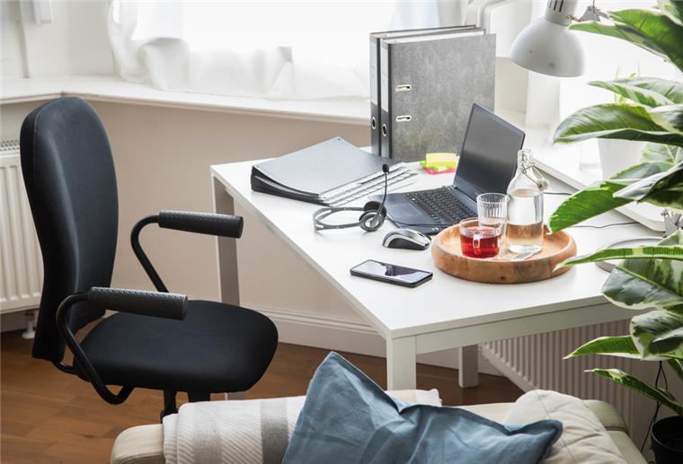Schreibtisch mit ausgeschaltetem Laptop.
