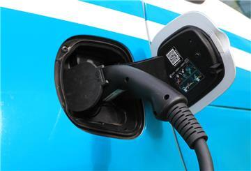 Ein Ladekabel steckt an einem Elektroauto,vor einer Ladesäule für E-Autos. Wer viel Strom verbraucht, beispielsweise durch den Besitz eines E-Autos, der kann mit dynamischen Stromtarifen viel Geld sparen.