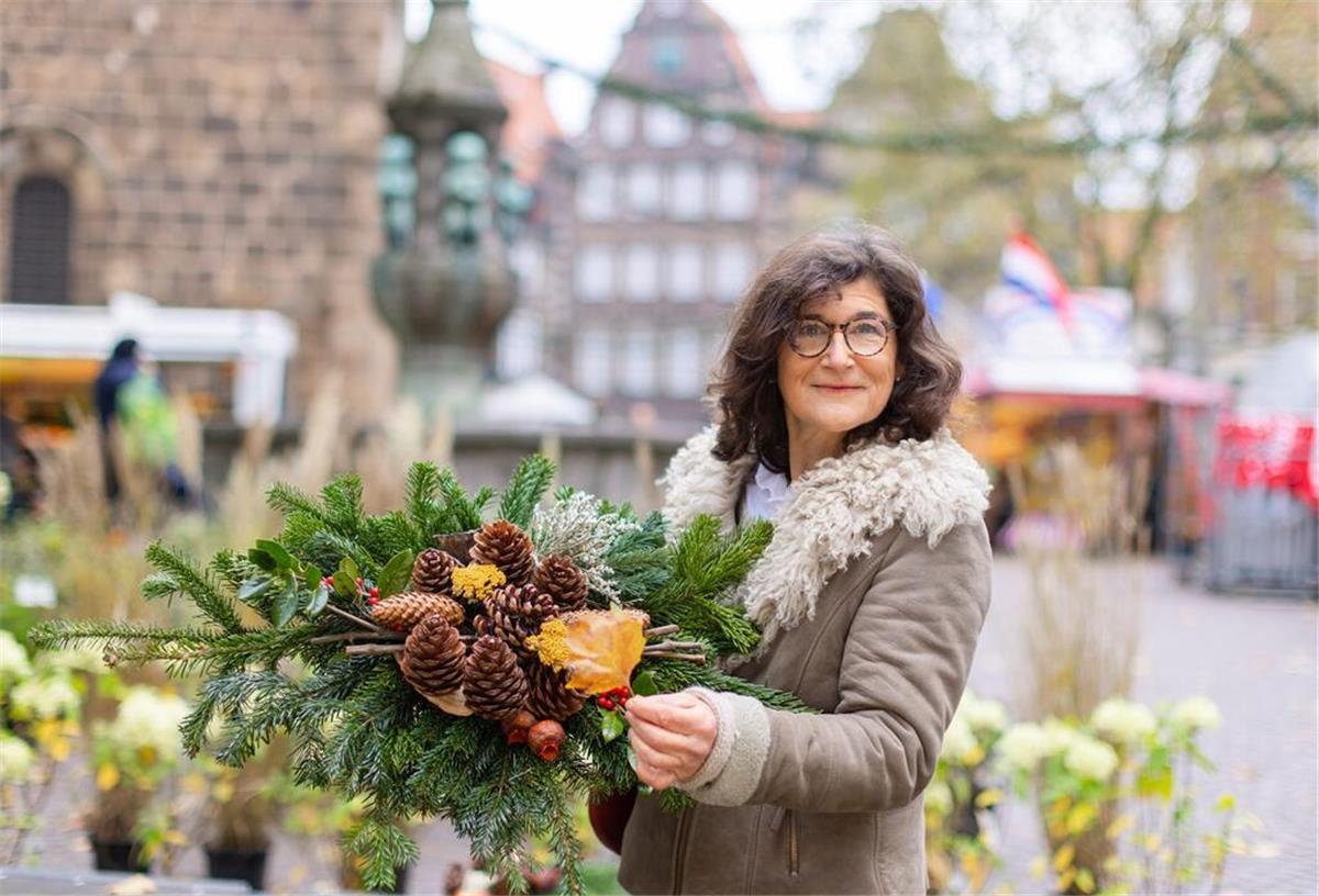 Eine Frau hält ein Gesteck