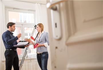 Eine Frau steht am 09.04.2019 in einer Wohnung in Hamburg und ueberreicht einem Makler Geld (gestellte Szene)