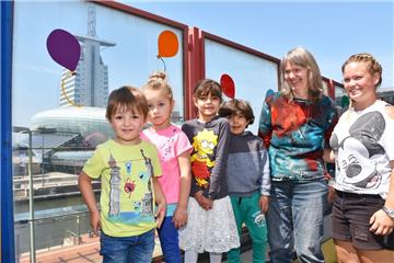 Werden mit Blick auf die Havenwelten und die Weser groß: Die Kinder der Kindertagesstätte Columbus-Center. Erzieherin Alexandra Hagner (rechts) und Frauke Schehl (2. von rechts) passen auf die Kleinen auf. 