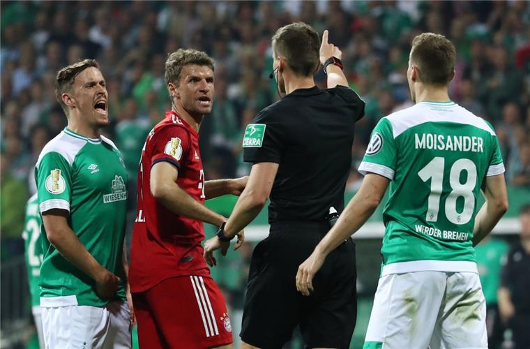 Werder Bremens Max Kruse und Münchens Thomas Müller diskutieren mit Schiedsrichter Daniel Siebert.