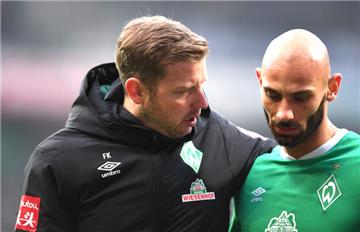 Werder Trainer Florian Kohfeldt spricht mit Ömer Toprak auf dem Weg in die Halbzeit.
