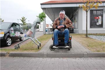 Wie ein unüberwindlicher Abgrund: Günter Ehrensberger im Rollstuhl vor dem Bordstein im Spadener Einkaufpark.  