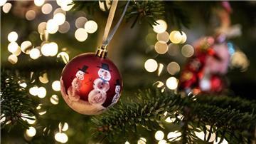 Eine Weihnachtskugel hängt an einem Weihnachtsbaum mit einer Lichterkette. Weihnachten, das Fest der Familie und der Liebe - doch mancher bleibt an Heiligabend einsam und gerät aus anderen Gründen in eine Krise. +++ dpa-Bildfunk +++