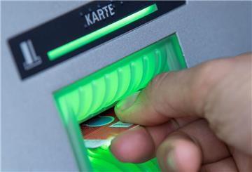 Eine Bankkundin steckt ihre Girokarte in einen Geldautomaten. Wie viel Geld haben Deutsche im Durchschnitt auf dem Girokonto? Die Umfrage einer Bank gibt Aufschluss.
