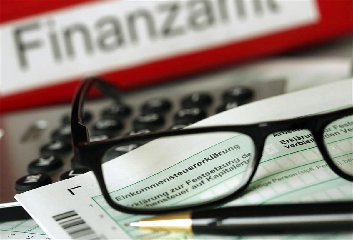 Rente wird Steuerfalle! So kann der Ruhestand richtig teuer werden Eine Brille liegt vor einem Finanzamt Ordner.