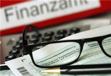Eine Brille liegt vor einem Finanzamt Ordner. 