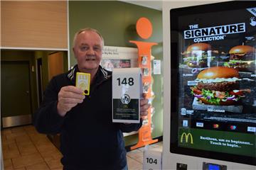Winfried Nagel, Inhaber des McDonald's-Restaurants in Nordenham, hält zwei Funkgeräte hoch, die für den Tischservice eingesetzt werden. Die kleineren wurden andauernd von Gästen eingesteckt und mitgenommen. Deshalb wechselte er jetzt zu der größeren Variante.