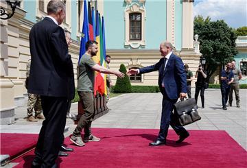 Wolodymyr Selenskyj (M), Präsident der Ukraine, begrüßt Bundeskanzler Olaf Scholz (r, SPD). Bundeskanzler Scholz