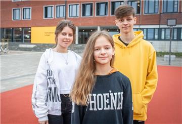 Zarina (16), Christina (11) und Vitaly (15) vor ihrer neuen Schule: dem Gymnasium Langen.