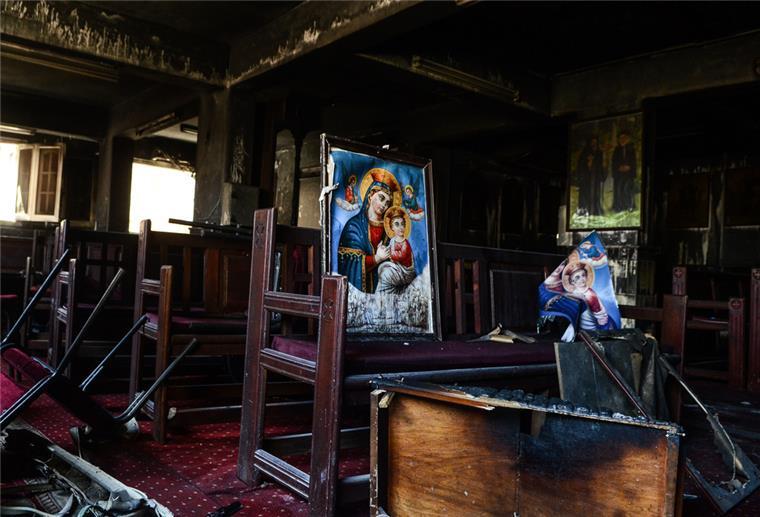 Zerstörte religiöse Bilder stehen auf einer Holzbank in der koptischen Abu-Sefein-Kirche, nachdem dort ein Großbrand ausgebrochen ist.