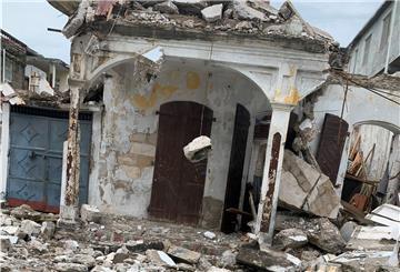 Der Rest eines eingestürzten Gebäudes in Haiti steht inmitten von Trümmerteilen und Geröll.