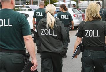 Zollbeamte kontrollieren Mitarbeiter in Einzelhandelsunternehmen und Gaststätten in einem Einkaufszentrum.