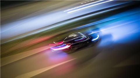 Zu Lichtspuren verwischt sind die Fahrzeuge auf einer Straße.