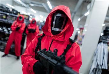 Mitarbeiter des Kostümhändlers Deiters posieren in Kostümen aus der Serie "Squid Game" des Streaming-Anbieters Netflix.