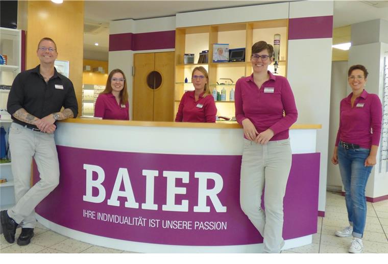 Teamfoto von BAIER OPTIK & AKUSTIK vor dem Tresen.