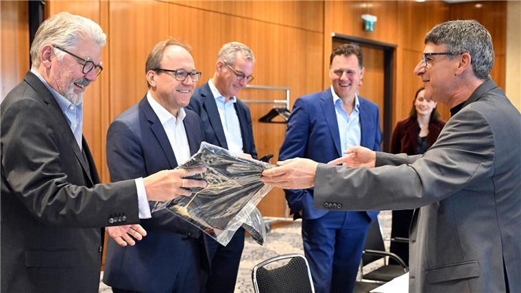 Stahlbranche in „schwieriger Lage“ - Tarifgespräche begonnen Zum Beginn der Tarifverhandlungen in der Stahlindustrie überreicht der Verhandlungsführer der IG Metall, Knut Giesler, zwei T-Shirts an den Verhandlungsführer der Arbeitgeber, Reiner Blaschek (2.v.l), sowie den Geschäftsführer des Arbeitgeberverbandes Stahl, Gerhard Erdmann (l).